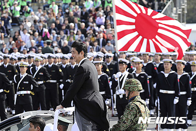 ▲ 2016년 10월 육상자위대를 사열하는 아베 신조 日총리 뒤로 욱일기가 보인다. ⓒ뉴시스 AP. 무단전재 및 재배포 금지.