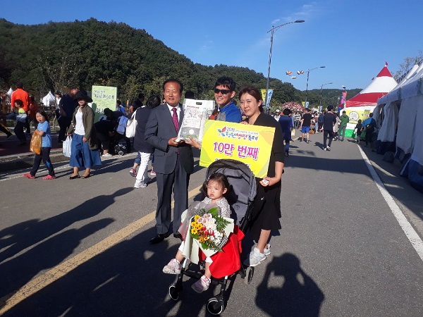 ▲ 청원생명축제 10만명째 입장객인 이병규씨 가족이 8일 하재성 청주시의회장으로부터 쌀 선물을 받고 있다.ⓒ청주시