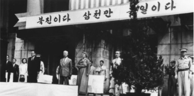 ▲ 1951년 현 경남도청 인근의 당시 임시정부청사에서 6.25 1주년 기념행사가 거행되고 있다. 사진 속 현수막에 '북진이다. 삼천만 통일이다' 글귀가 보이고 그 밑에 이승만 대통령과 프란체스카 여사의 모습이 보인다.ⓒ이승만포럼 제공