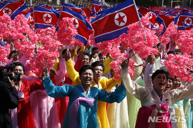 ▲ 북한이 지난 9월 9일 정권수립 70주년을 맞아 평양에서 대규모 군대 퍼레이드를 벌이고 있는 가운데 한복을 입을 북한 참가자들이 북한 인공기와 꽃을 흔들며 환호하고 있다. ⓒ 뉴시스