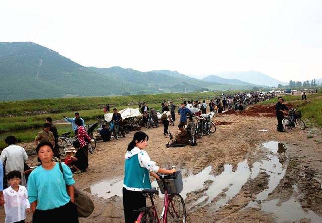 ▲ 고난의 행군 시기 북한당국의 엄격한 통제로 인해 암시장은 임의 장소에서 수시로 만들어졌다가 해체되기를 반복했다. 2000년대 초 평안남도의 한 지역에서 임시로 만들어진 암시장 ⓒ Bai Du