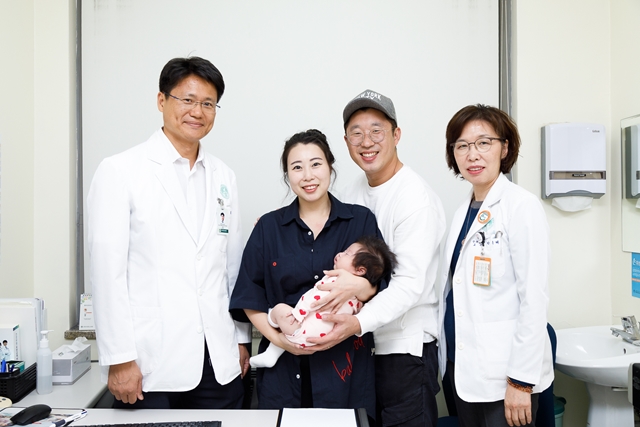 ▲ 간이식 후 임신·출산에 성공한 박혜령 씨 가족과 이대목동병원 의료진이 기념 촬영을 하고 있는 모습. (왼쪽부터 홍근 간센터 교수, 박혜령 씨, 박혜령 씨 남편, 박미혜 산부인과 교수) ⓒ이대목동병원