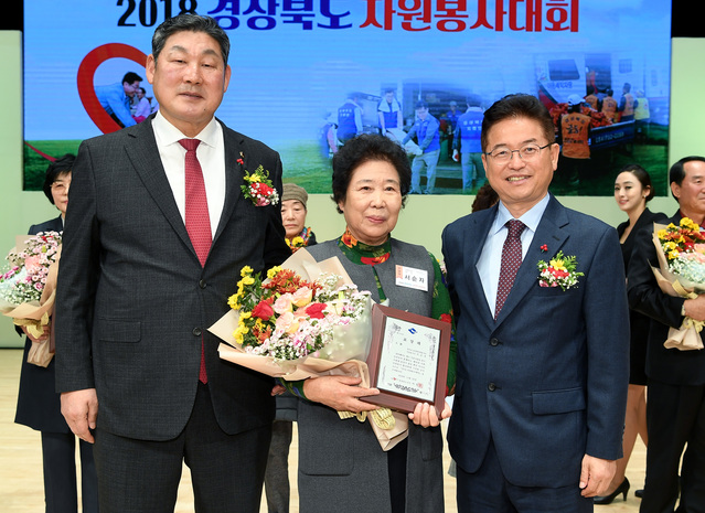 ▲ 경북도 ‘2018 자원봉사자대회’가 20일 도청 동락관에서 도내 1천여 명의 자원봉사자들이 모인 가운데 열렸다. 올해 대상의 영예를 안은 성주군 서순자(중간)씨가 이철우 지사(오른쪽)와 장경식 도의회 의장과 기념촬영을 하고 있다.ⓒ경북도