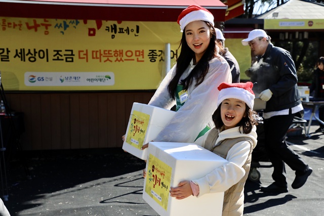 ▲ 2018 미스코리아 선 송수현양이 GS건설 임직원 자녀와 함께 포장된 김치 박스를 운반하고 있다. ⓒGS건설