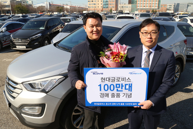 ▲ 현대글로비스의 중고차 경매 누적 출품 대수가 업계 최초로 100만대를 돌파했다. 11월30일 100만번째 중고차인 현대차의 ‘싼타페’를 출품한 강철상 씨(왼쪽)가 현대글로비스 시화경매장에서 이종성 센터장(오른쪽)과 기념사진을 찍고 있다.ⓒ현대글로비스