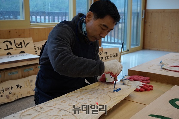 ▲ 한 농민이 목판에 새긴 농장이름 위에 공을 들여 페인트칠을 하고 있다.ⓒ김정원 기자