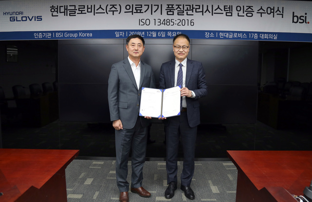 ▲ 김현중 현대글로비스 기획실장(전무, 좌측)이 6일 서울 강남 역삼동 현대글로비스 본사에서 이종호 BSI코리아 대표이사로부터 ISO 13485(의료기기품질경영시스템) 인증서를 받은 뒤 기념 촬영을 하고 있다.ⓒ현대글로비스