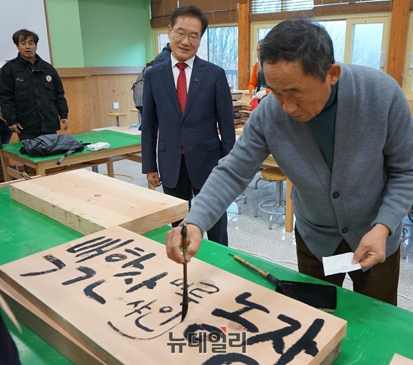 ▲ 강우현 제주 탐나라공화국 대표가 지난 5일 경북 영천시 화북면 입석리 영천목재문화체험관에서 나무 목재에 농장 이름을 새길 밑그림을 새기자 최기문 영천시장이 흥미롭게 바라보고 있다.ⓒ김정원 기자