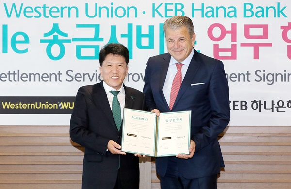 ▲ 함영주 KEB하나은행장(왼쪽)이 지난 11일 본점에서 웨스턴 유니온 힉멧 얼섹(Hikmet Ersek) 회장과 업무협약을 체결한 후 기념촬영을 하고 있다. ⓒKEB하나은행