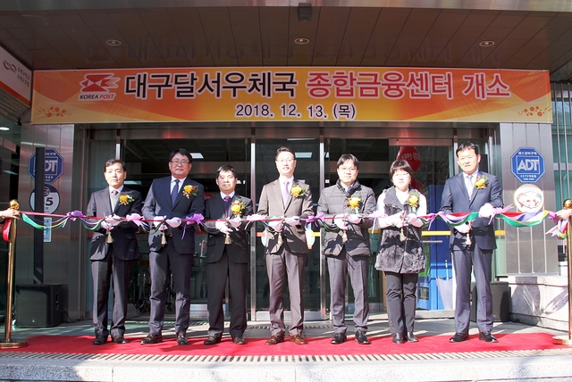 ▲ 13일 대구달서우체국 우체국 종합금융센터 개소식에서 홍진배 경북우정청장(사진 왼쪽부터 네번째), 신대섭 우정사업본부 예금사업단장(왼쪽에서 세번째)을 비롯한 참석자들이 기념테이프 커팅을 하고 있다.ⓒ경북우정청