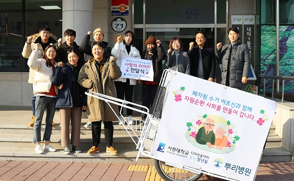 ▲ 웃는 청년들, 폐지 수거인, 내덕 1동 주민센터 관계자들이 손수레 전달식 후 기념사진을 촬영하고 있다.ⓒ서원대학교