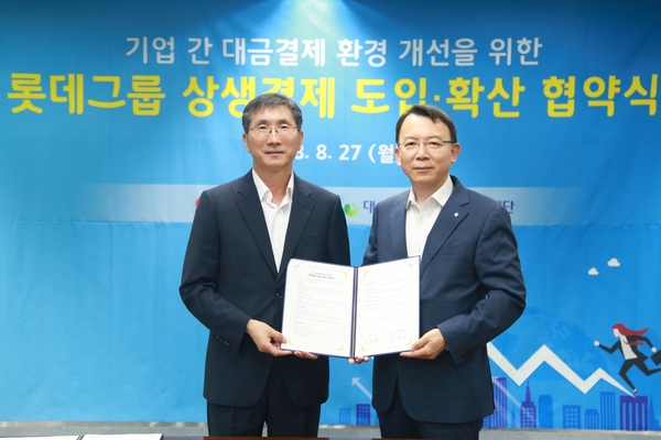 ▲ 오성엽 롯데지주 부사장(오른쪽)과 김형호 대·중소기업·농어업협력재단 사무총장이 지난 8월 27일 서울 구로 대·중소기업·농어업협력재단에서 ‘상생결제 도입·확산’ 협약식을 마친 후 기념사진을 찍고 있다. ⓒ롯데