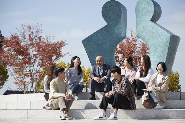 ▲ 정성봉 총장이 대학 상징물 앞에서 학생들과 이야기를 나누고 있다.ⓒ청주대