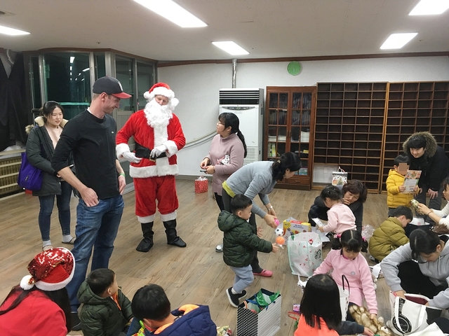 ▲ 대구 거주 외국인들이 산타복장을 하고 전달한 선물을 아동보호시설의 어린이들이 각자의 선물을 열어보고 있다.ⓒ수성구
