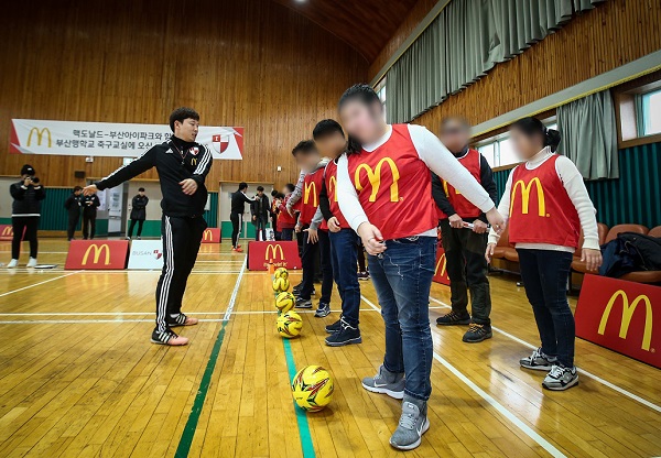 ▲ [사진1] 20일 로날드 맥도날드 어린이 축구교실에 참가한 부산맹학교 시각 장애 학생들이 부산아이파크 코치의 지도 아래 몸을 풀고있다ⓒ맥도날드