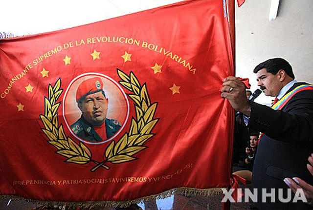 ▲ 우고 차베스 1주기 기념 퍼레이드 때 차베스 사진이 그려진 깃발을 들어보이는 니콜라스 마두로 現대통령. ⓒ뉴시스-신화. 무단전재 및 재배포 금지.