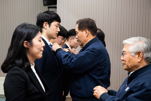 ▲ 정몽익 KCC 사장(우측 두 번째)이 '2019 KCC 신입사원 입사식'에서 신입사원에게 KCC 배지를 수여하고 있다. ⓒKCC