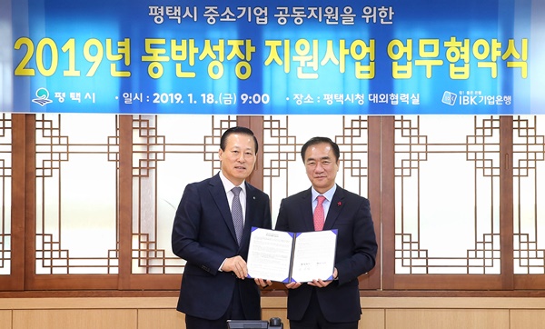 ▲ 김도진 기업은행장(왼쪽)이 18일 평택시청에서 정장선 평택시장이 업무협약을 체결하고 기념촬영을 하고 있다. ⓒIBK기업은행