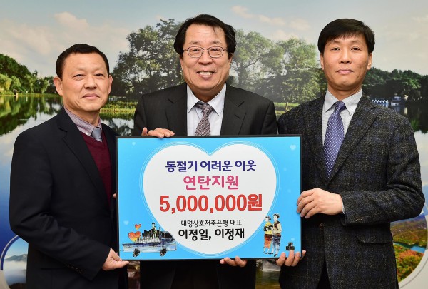 ▲ 이정재 대명상호저축은행 공동대표(오른쪽)가 이상천 시장에게 연탄을 전달하고 있다.ⓒ제천시