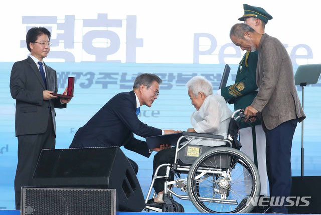 ▲ 문재인 대통령이 서울 용산구 국립중앙박물관 열린마당에서 열린 제73주년 광복절 및 정부수립 70주년 경축식에서 고 손용우 선생에 대한 건국훈장 애족장을 배우자 김경희 씨에게 수여하고 있다. ⓒ뉴시스. 무단전재 및 재배포 금지.