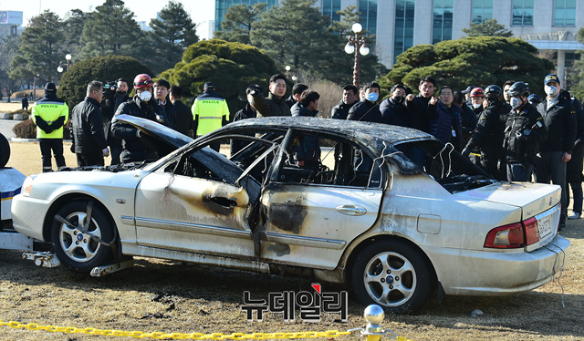 ▲ 1일 오전 서울 여의도 국회 잔디광장에서 한 60대 남성이 승용차를 몰고 와 불을 질렀다. 경찰 및 소방당국 관계자들이 해당 승용차에 대한 감식 작업을 벌이고 있다. ⓒ정상윤 기자