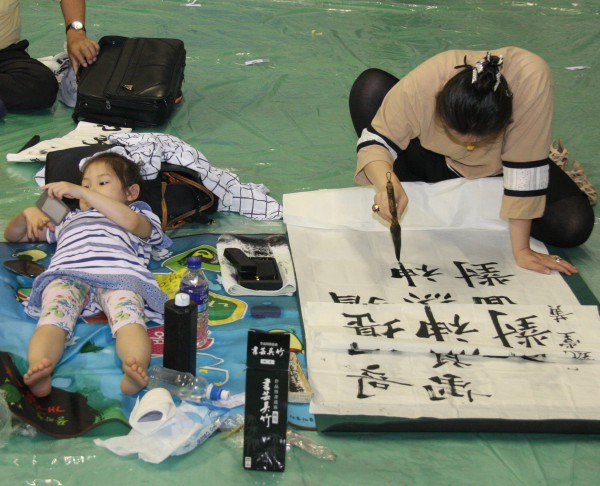 ▲ 소백산철쭉제기념으로 매년 열리는 퇴계이황 전국서예대회. 지난해 대회에서 엄마는 붗글씨에 열중하고 따라온 아이는 핸드폰 게임에 빠져 있는 모습.ⓒ목성균 기자