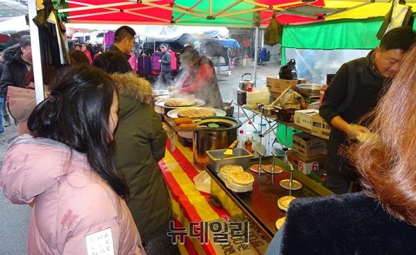 ▲ 날씨가 추운 탓에 시장을 보러 온 사람들이 호떡집에서 오뎅국물을 마시며 추위를 녹이고 있다.ⓒ박근주 기자