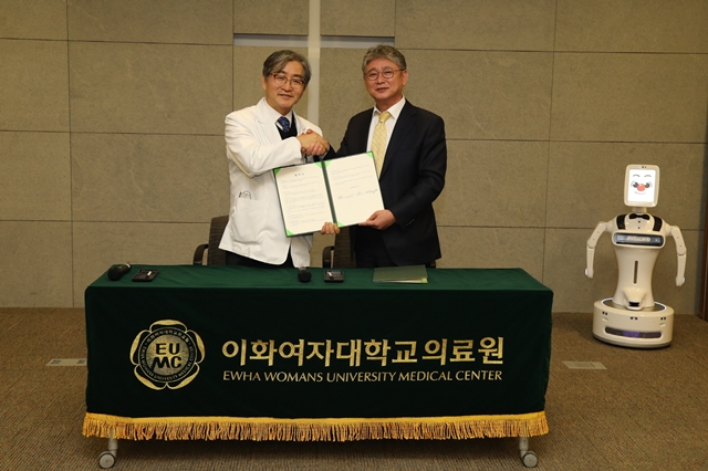 ▲ 문병인 이화여자대학교 의무부총장 겸 의료원장(왼쪽)과 김덕준 로보케어 대표이사(오른쪽)이 지난 12일 업무 협약 체결 후 기념촬영을 하고 있다. ⓒ이화의료원