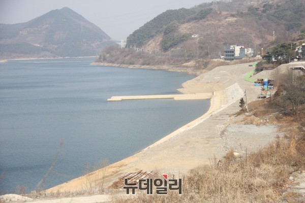 ▲ 단양수중보가 충주댐 만수위로 보가 물에 잠긴 채 주변 진입도로 공사가 중단돼 비포장 상태에서 바람에 먼지가 날리고 있는 모습.ⓒ목성균 기자