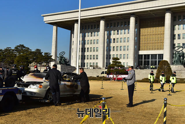 ▲ 1일 오전 국회 잔디밭에서 분신으로 추정되는 승용차에 화재가 발생해 소방대원들과 경찰 관계자들이 감식 작업을 벌이고 있다. 이종현 기자