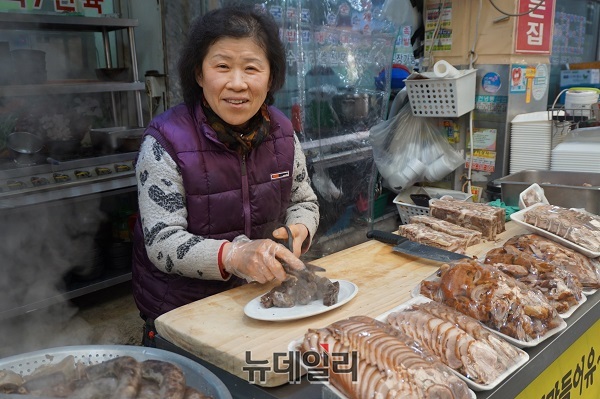 ▲ 증평장뜰시장에서 순대를 판매하고 있는 증평순대 이련해 대표가 순대를 썰며 환하게 웃고 있다.ⓒ김정원 기자