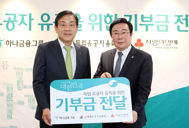 ▲ 26일 하나금융지주 명동 사옥에서 진행된 기부금 전달식에서 김정태 하나금융그룹 회장(사진 왼쪽)과 김삼열 독립유공자유족회 회장(사진 오른쪽)이 기념촬영을 하고 있다.ⓒKEB하나은행