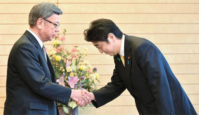 ▲ 2015년 4월 미군기지 이전문제에 항의하기 위해 도쿄 총리관저를 찾은 오나가 다케시 당시 오키나와현 지사(왼쪽)와 그를 맞이하는 아베 신조 일본 총리(오른쪽). ⓒ뉴시스 AP. 무단전재 및 재배포 금지.