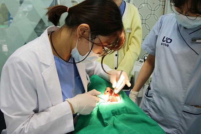 ▲ 유디치과의 ‘우리동네 이 밝은 세상’ 대상자로 선정된 김 군(14세)이 치아 검진을 받고 있는 모습 ⓒ유디치과
