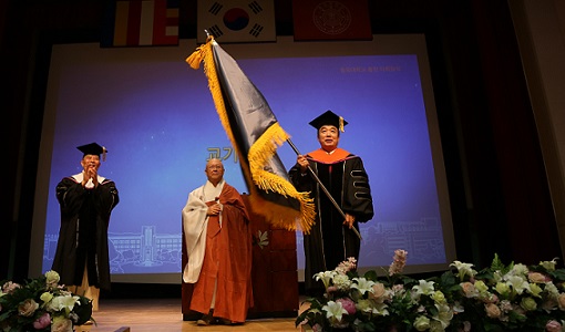 ▲ 28일 서울 중구 동국대학교에서 열린 '제19대 총장 취임식'에서 윤성이 신임 총장(오른쪽)이 교기를 흔들고 있다. ⓒ동국대