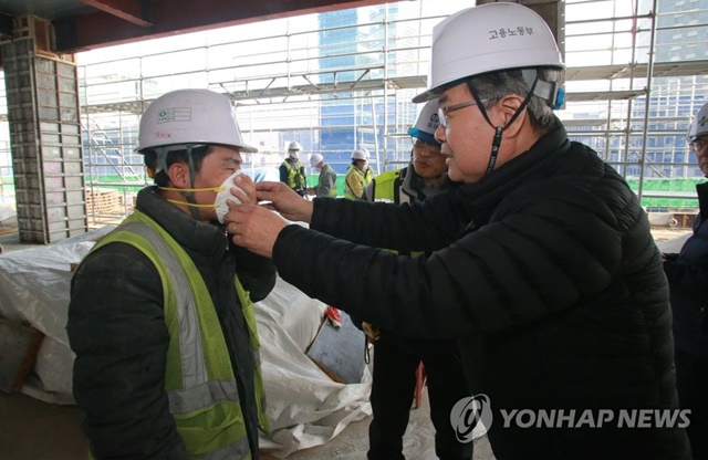 ▲ 이재갑 고용노동부 장관이 지난달 서울 종로구에 있는 건설현장을 찾아 근로자에게 미세먼지 보호용 마스크를 씌워주고 있다. ⓒ연합뉴스