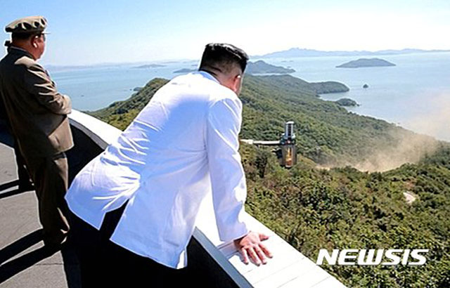 ▲ 2016년 9월 서해 동창리 미사일 시험장의 귀빈석에서 로켓 엔진 시험을 보는 김정은. ⓒ뉴시스. 무단전재 및 재배포 금지.