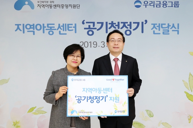 ▲ 우리금융은 12일 서울시 중구 회현동 본사에서 ‘지역아동센터 맑은 공기 지원사업 물품 전달식’를 갖고 공기청정기를 지역아동센터에 전달했다. 손태승 우리금융 회장(사진 오른쪽)이 박영숙 지역아동센터중앙지원단 단장과 기념 촬영을 하고 있다.ⓒ우리금융