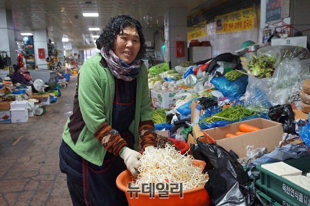 ▲ 옥천공설시장 한 여성 상인이 고객들에게 판매할 콩나물을 다듬고 있다.ⓒ김정원 기자