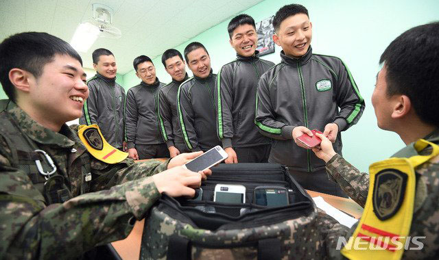 ▲ 부대 복귀 때 받아 보관하던 개인 스마트폰을 돌려주는 당직사관. 이제 군대는 각자 침대를 쓰고 매월 수십만 원의 월급을 받으며, 스마트폰도 쓰고, 외출도 가능한 곳이 됐다. ⓒ뉴시스. 무단전재 및 재배포 금지.