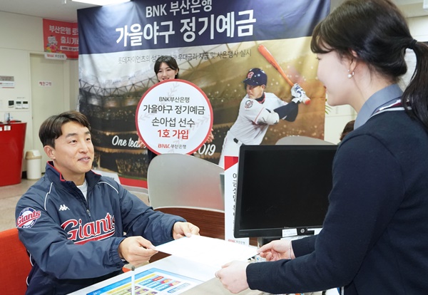 ▲ 'BNK부산은행 가을야구 정기예금' 모델인 롯데자이언츠 손아섭 선수가 22일 사직운동장지점에서 예금 1호 고객으로 가입하고 있는 모습. 
 ⓒBNK부산은행