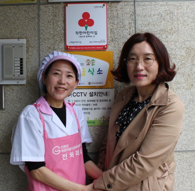 ▲ 진천군어린이급식관리지원센터 관계자가 으뜸급식소로 선정된 진천 나래숲 어린이집 현관에 현판을 걸고 기념촬영을 하고 있는 모습.ⓒ한국교통대