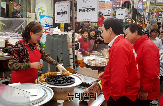 ▲ 21일 황교안 자유한국당 대표가 창원 반송시장에서 4.3보궐선거 유세를 하고 있다. 시장상인에게서 국화빵을 주문한 황 대표가 주머니에서 돈을 꺼내는 모습. 임혜진 기자