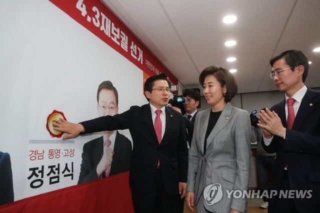 ▲ 3일 오후 11시 30분경 황교안 자유한국당 대표가 국회의원 보궐선거 개표 결과를 지켜본 뒤 통영고성 지역구에 당선된 정점식 당선인의 사진에 당선 스티커를 붙이고 있다.ⓒ연합뉴스