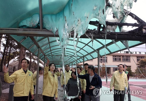 ▲ 지난 6일 강원 산불 피해를 본 강릉시 옥계중학교를 찾은 유은혜 부총리 겸 교육부 장관 등이 녹아내린 연결 지붕을 살펴보고 있다. ⓒ연합뉴스