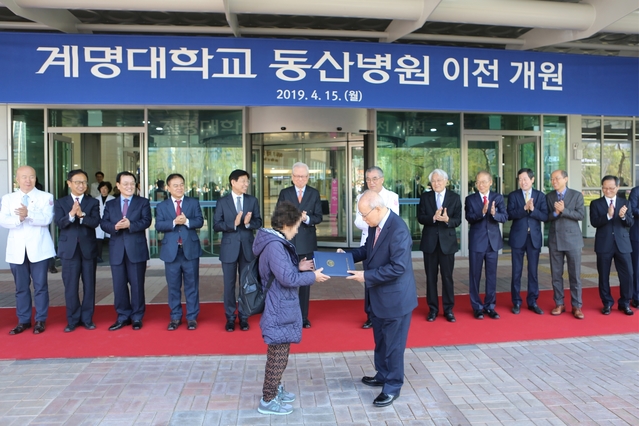 ▲ 김권배 의료원장이 병원 첫 환자에게 방문선물을 주고 있다.ⓒ동산병원