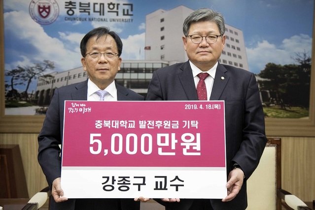 ▲ 강종구 교수(왼쪽)가 18일 김수갑 총장에게 5000만원을 전달하고 있다.ⓒ충북대