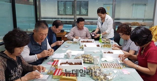 ▲ 제천약초시장 내 제천산삼전시판매장 2층에서 국내산 한약재로 공진단을 만들고 있는 주민과 관광객들 모습.ⓒ목성균 기자