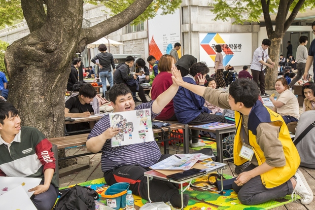 ▲ 지난 23일 국립민속박물관에서 열린 '서울발달장애인 사생대회에서 장애인 참가자와 CJ그룹 임직원 자원봉사자들이 함께 즐거운 시간을 보내고 있다.ⓒCJ