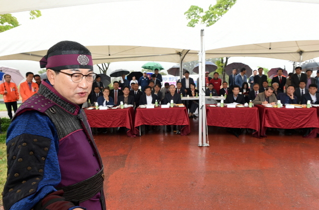 ▲ 주낙영 경주시장이 부지선정위원들에게 화랑복을 입고 비를 맞으며 조감도를 브리핑하고 있다.ⓒ경주시